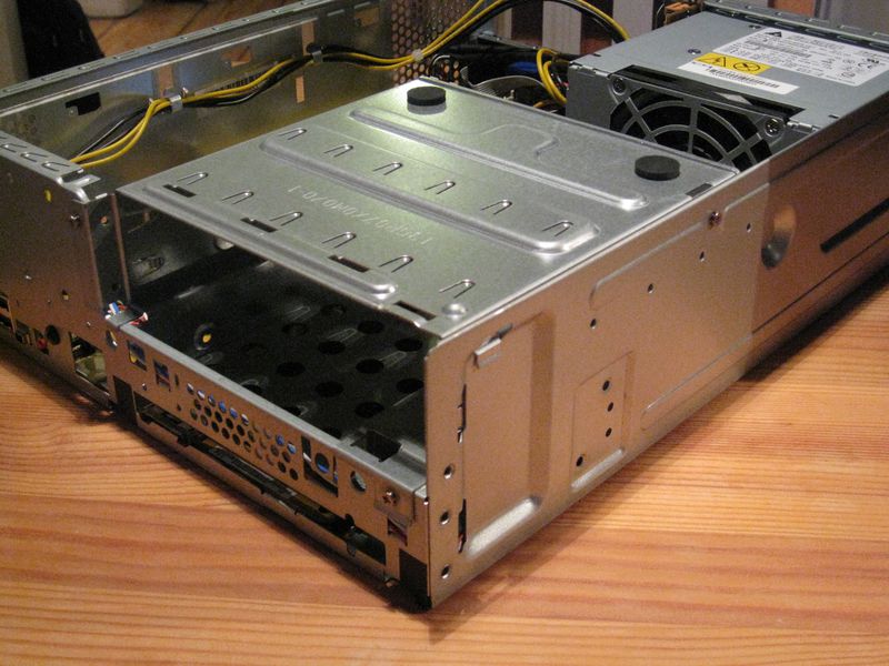 File:Hard disk and optical drive cage; the three screws attaching it to the case are partially removed..jpg